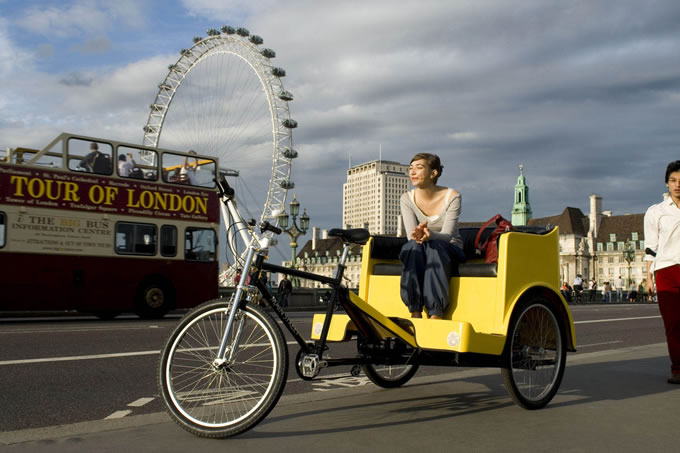 A pedicab in london with the london eye in the background